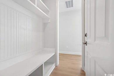 Mudroom with light wood-style floors and baseboards