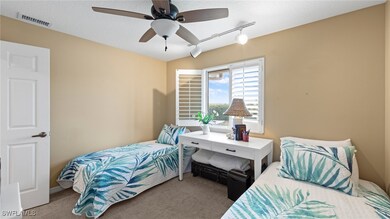 Carpeted bedroom with track lighting and ceiling f