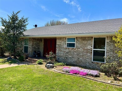 Ranch-style home with brick siding, a shingled roof, and a front lawn