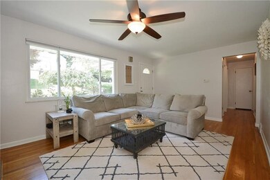 The sunlit living room features beautiful hardwood