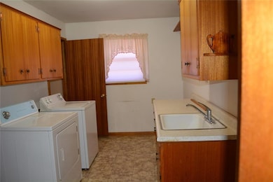 Washroom featuring washer and dryer, cabinets, and sink