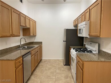 Kitchen with light tile patterned floors, white ap