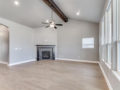 Unfurnished living room featuring ceiling fan, a f