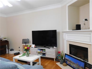 Living room featuring crown molding, wood finished