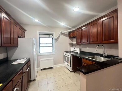 Kitchen featuring white appliances, light tile patterned floors, and recessed lighting