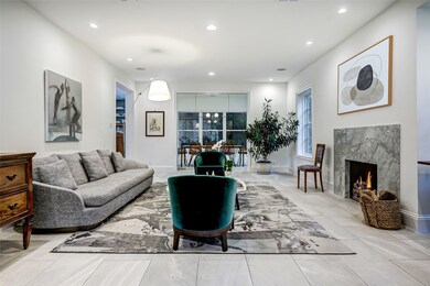 The open-plan living room invites you to relax and unwind in front of south-facing Pella windows and a gas fireplace featuring a marble surround.