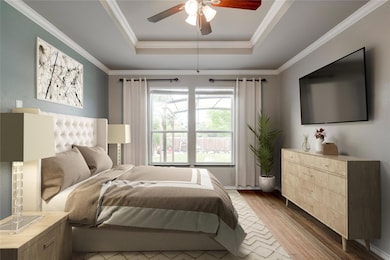 Bedroom with a raised ceiling, wood finished floo