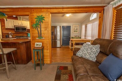 Living room with light colored carpet and vaulted 