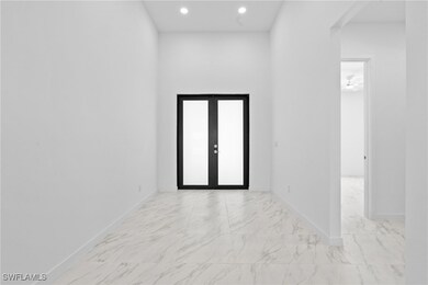 Unfurnished room featuring baseboards, french door