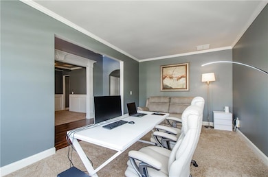 Office area featuring crown molding and carpet