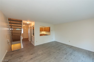 Unfurnished living room featuring wood finished floors and baseboards
