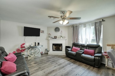 Living area with a fireplace, a ceiling fan, and 