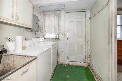 Laundry area featuring cabinet space, electric panel, and washing machine and clothes dryer