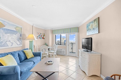 Living room featuring crown molding, light tile pa