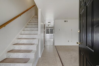 Staircase featuring tile patterned flooring, carpet flooring, and visible vents