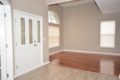 Living room/bonus room with hardwoods. Notice arched palladium window. Bonus room as 12' ceiling.