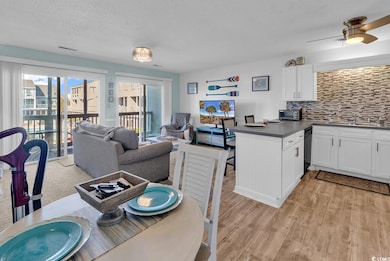 Dining space with a textured ceiling, a ceiling fan, and light wood-style floors