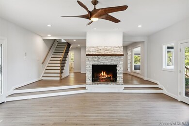 Unfurnished living room featuring a stone fireplac
