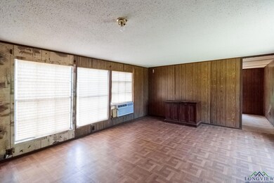 Unfurnished room featuring wooden walls and a textured ceiling