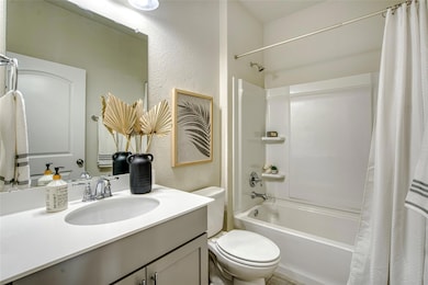 Bathroom with shower / tub combo, vanity, and a t