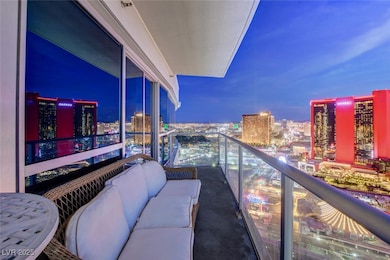 Balcony at night featuring a view of city lights