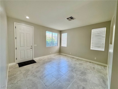Tiled foyer entrance with baseboards and recessed