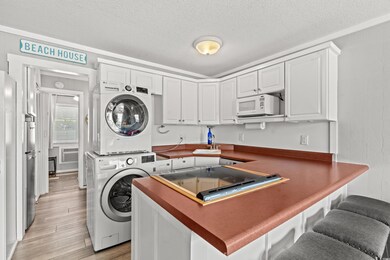 Clothes washing area featuring a textured ceiling,