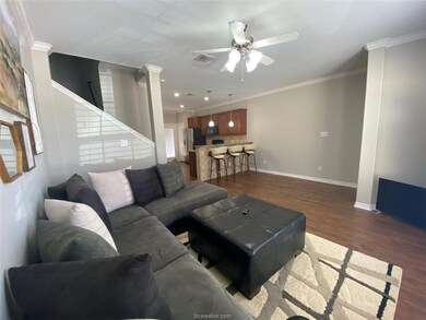 Living area with ceiling fan, decorative columns,