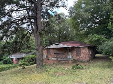 View of front facade featuring brick siding, a porch, and a front yard