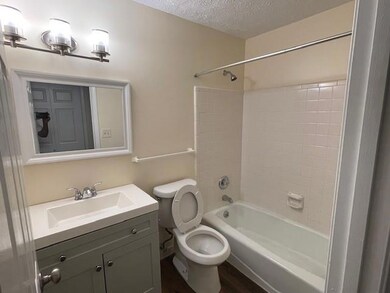 Full bathroom featuring vanity, a textured ceiling,  shower combination, and wood finished floors