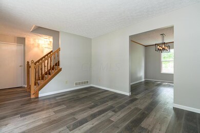 living room with view of dining and stai