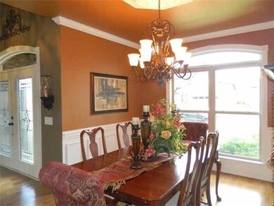 Dining Room: 11 x 14 :Elegant Formal Dining Room with crown molding, hardwood flooring, wainscoting, double window with eyebrow transom above, opens to the Foyer Area and cased opening to access the Kitchen