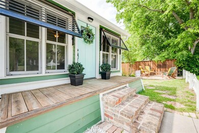 Brick front steps lead to a small porch with decor