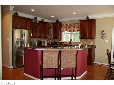 Kitchen - Gourmet kitchen with granite counters, handsome tile backsplash,  cherry cabinets, crown molding, Island with seating area, & stainless steel appliances, built in microwave and oven is at rear. as is the bar. The office is located down the 