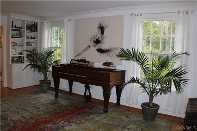Light, bright living room with built in bookcases, wood burning fireplace, crown molding & hardwood floors!