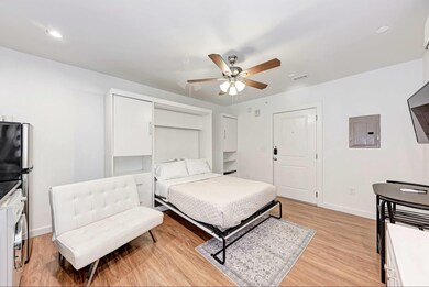 Bedroom featuring electric panel, light wood-styl