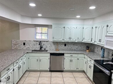 Kitchen with light tile patterned floors, a sink,