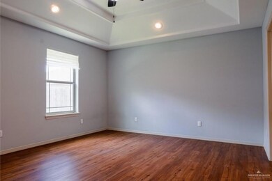 Spare room with hardwood / wood-style floors, a tray ceiling, and ceiling fan