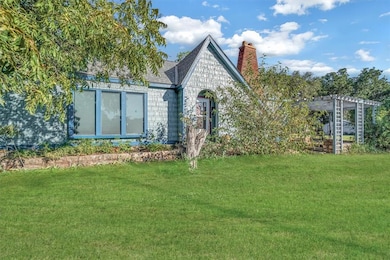 Front view of property featuring a yard, a chimney, and a shingled roof