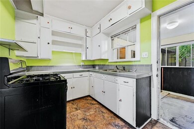 Kitchen with black range with gas stovetop, stain
