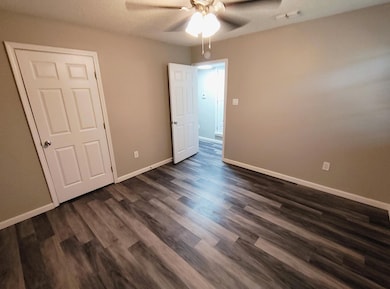 Unfurnished bedroom featuring ceiling fan, baseboa