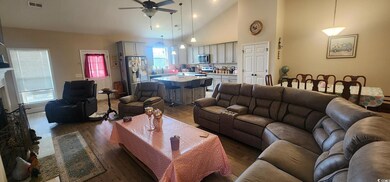 Living room with a fireplace, a ceiling fan, visib