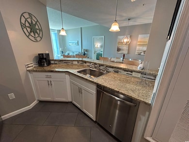 Kitchen featuring white cabinetry, a sink, stainle