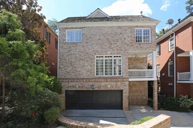 View of front of house with brick siding, a garage, and driveway