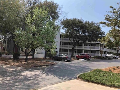 View of building exterior featuring uncovered parking