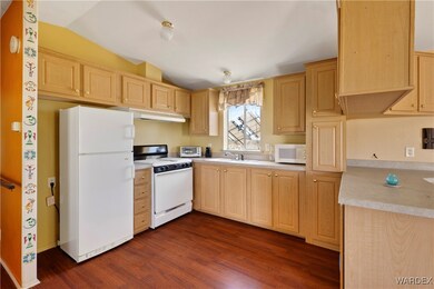 Kitchen with dark wood-style floors, white applian