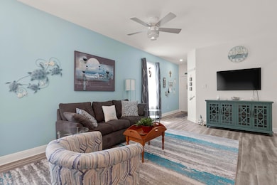 Living area featuring wood finished floors and a ceiling fan