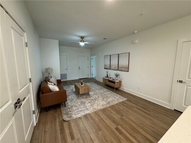 Living area featuring dark wood-style floors, visi
