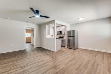 Unfurnished living room with ceiling fan and light