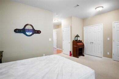 Carpeted bedroom with baseboards and visible vents